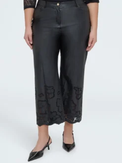 Pantaloni cropped in tessuto spalmato con motivi floreali