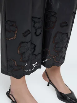 Pantaloni cropped in tessuto spalmato con motivi floreali
